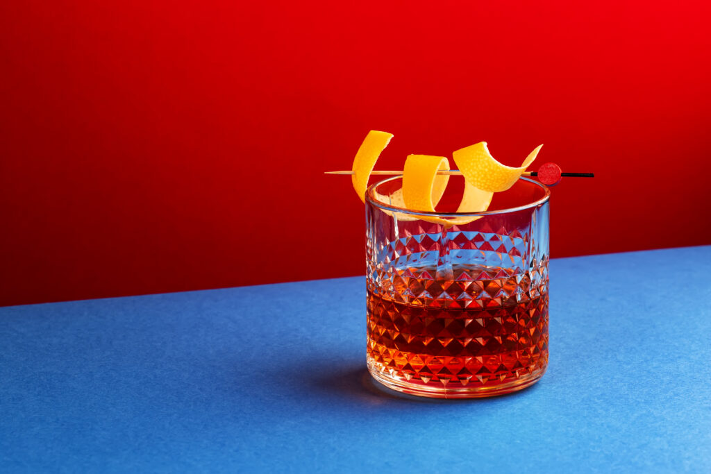 Sazerac cocktail med rød og blå baggrund